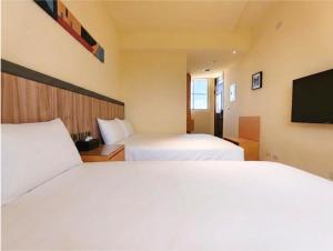 a hotel room with two beds and a flat screen tv at 好室行旅House inn 金門大學旁 近市區 in Jinning
