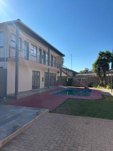 a house with a swimming pool in front of it at Urban Rest Guesthouse in Mahikeng