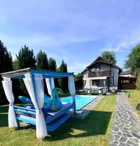 a pool with a gazebo next to a house at Casa Fred in Sîmbotin