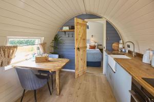 a kitchen with a table in a tiny house at Waters Edge Cabin in Helmsley +18 photos