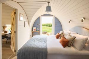 a bedroom with a bed with an arched doorway at Waters Edge Cabin in Helmsley
