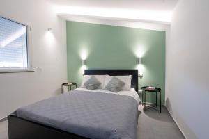 a bedroom with a large bed with two pillows at GiuMar Apartments Acitrezza in Aci Catena