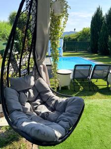 a black swing chair sitting on the grass next to a pool at Casa Fred in Sîmbotin