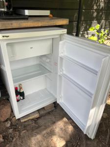 an open refrigerator with two bottles of beer in it at Glamping - a living room overlooking the ocean in Hammarland +21 photos