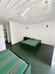 a room with two beds and a white wall at Green Techno Villa in Kitulkote