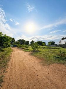 a dirt road in the middle of a field at Green Techno Villa in Kitulkote