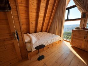 a small bed in a room with a window at M Place in Shārūn
