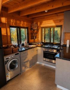 a large kitchen with stainless steel appliances and windows at M Place in Shārūn