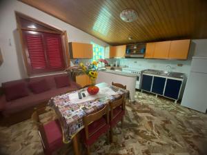 a kitchen with a table and a couch in a room at Sole di Lercara in Lercara Friddi