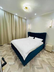 a bedroom with a large bed with a blue frame at Royal Villa in Yoliin Hural