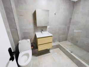 a bathroom with a toilet and a sink and a tub at Royal Villa in Yoliin Hural +3 photos