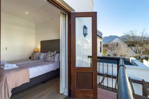 a bedroom with a bed and a balcony at Winelands Golf Lodges 11 in Stellenbosch +37 photos