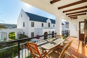 a patio with a table and chairs on a balcony at Winelands Golf Lodges 11 in Stellenbosch