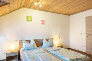 a bedroom with two beds in a room with wooden ceilings at Die Moderne Fewo in Breitenberg