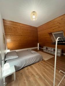 a bedroom with a bed and a wooden wall at Maison cozy in Saint-Brieuc