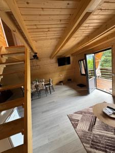 a room with a table and chairs in a wooden house at Roua Munților in Dârlești