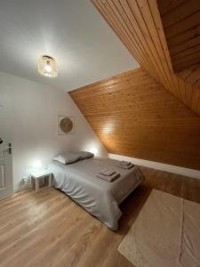 a bedroom with a bed and a wooden ceiling at Maison cozy in Saint-Brieuc +7 photos
