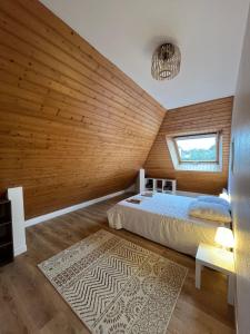 a bedroom with a bed and a wooden wall at Maison cozy in Saint-Brieuc