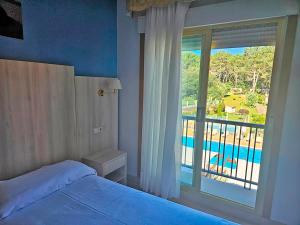 a bedroom with a bed and a window with a view of a pool at Hotel Mar del Norte 3000 in O Grove +64 photos