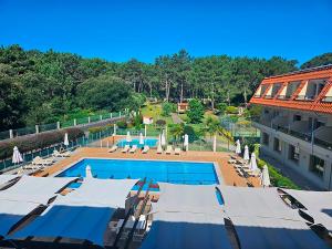 a swimming pool with umbrellas and a resort at Hotel Mar del Norte 3000 in O Grove