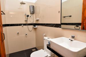 a bathroom with a sink and a toilet and a mirror at Bay Marina in Arugam Bay +23 photos