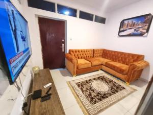 a living room with a couch and a flat screen tv at CBC Towers in Lagos +1 photo