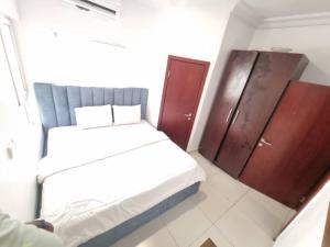 a small room with a bed and wooden cabinets at CBC Towers in Lagos