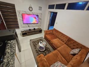 a living room with a brown couch and a flat screen tv at CBC Towers in Lagos