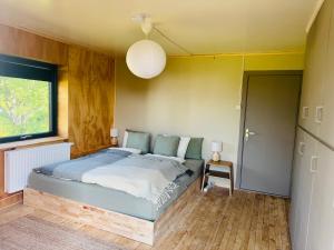 a bedroom with a bed and a window at Nykmark Eco Residence in Unnstad