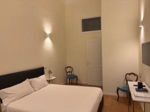 a bedroom with a bed and a table and chairs at Suite Indipendenza Perugia in Perugia
