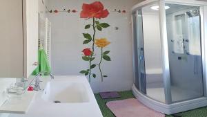 a bathroom with a sink and a shower with a flower on the wall at Suite indépendante de 66m2 tout confort et calme in Villefranche-de-Rouergue +27 photos