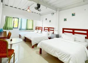 a room with three beds and a table and chairs at Moalboal Seaside Resort in Moalboal