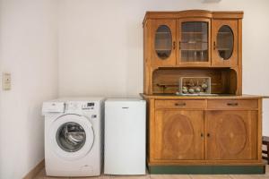 a laundry room with a washing machine and a wooden cabinet at Eifel Dream Zingsheld in Fleringen