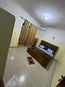 a living room with a television in a room at Auberge mfuma in Kisantu