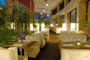 a restaurant with white tables and white chairs at Imperial Casablanca Hotel & Spa in Casablanca