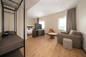 ein Wohnzimmer mit Sofa und Fernseher in der Unterkunft Fly Inn Hotel in Vragolija