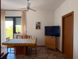 a dining room with a table and a flat screen tv at Casa Raffaella in Polignano a Mare