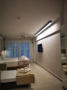 a hotel room with two beds and a light on the wall at Plagia Relax Hotel in Nea Plagia