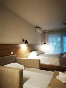 a hotel room with two beds and a window at Plagia Relax Hotel in Nea Plagia