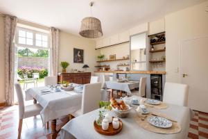 a kitchen and dining room with tables and chairs at B&B Clerval - Maison d'hôtes et Gîtes in Dragey