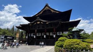 a large building with people walking in front of it at サカナギゲストハウス in Nagano