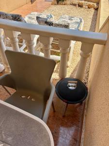 a table and a stool with a plate on it at Tranquil Self Catering Golf Course Apartment in Alicante