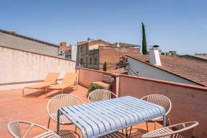 a patio with chairs and a blue table and chairs at Majordoms Ponent in Banyoles