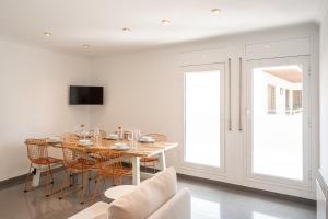 a white dining room with a table and chairs at Majordoms Ponent in Banyoles