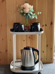 a table with a tea kettle and plates and flowers at Issyk-Kul Glamping in Chon-Sary-Oy