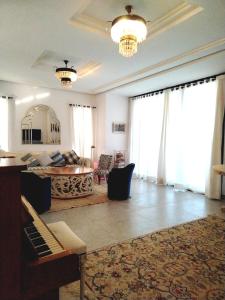 a living room with a piano and a couch at Sainte Madeleine in Boumhel El Bassatine +18 photos