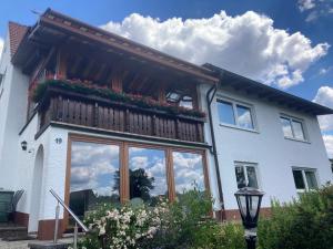 a house with a balcony with flowers on it at Ferienwohnung Loni in Kulmbach