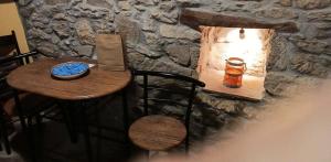 a small table with a candle on a stone wall at Thetis Stone Residence in Volissos