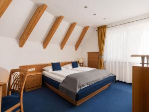 a bedroom with a bed and a desk and a table at Hotel Montis - Active Nature Resort in Brunico +111 photos