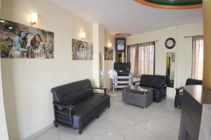 a living room with black chairs and a table at Hotel highway inn in Gandhidham